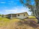 Home exterior featuring screened-in patio, mature trees and a well-maintained lawn at 6263 Sw 107Th St, Ocala, FL 34476