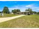 Spacious home with a long driveway and well-kept lawn, set in a peaceful neighborhood under a blue sky at 6263 Sw 107Th St, Ocala, FL 34476
