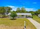 Inviting single-level home featuring a covered carport and front porch, surrounded by a green lawn and clear blue skies at 6263 Sw 107Th St, Ocala, FL 34476
