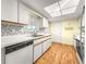 Bright kitchen with white cabinets, backsplash, and wood-look flooring at 6263 Sw 107Th St, Ocala, FL 34476
