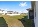 View of the spacious backyard with a white fence, green grass and a covered patio at 6342 Sw 77Th Ave, Ocala, FL 34474