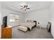 Bright bedroom with a tray ceiling, ceiling fan, and neutral tones creating a serene atmosphere at 6342 Sw 77Th Ave, Ocala, FL 34474
