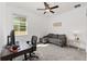 Bright bedroom featuring a ceiling fan, window with natural light, sofa and carpeted floors at 6342 Sw 77Th Ave, Ocala, FL 34474