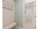Inviting mudroom with shaker-style wall, coat hooks, bench, and access to the laundry room at 6342 Sw 77Th Ave, Ocala, FL 34474