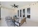 Covered patio with ceiling fan, string lights, and cozy seating, seamlessly connected to the home's interior at 6342 Sw 77Th Ave, Ocala, FL 34474