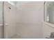 Detailed view of the neutral tiled shower with a frameless glass door and chrome fixtures at 6342 Sw 77Th Ave, Ocala, FL 34474