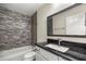 Bathroom features a bathtub with decorative tile surround and a vanity with a dark countertop and framed mirror at 6600 Sw 109Th Ln, Ocala, FL 34476