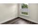 Bedroom with hardwood flooring, light walls, white trim, and a window overlooking the fenced backyard at 6600 Sw 109Th Ln, Ocala, FL 34476