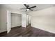 Bedroom with dark wood floors, an open closet, a ceiling fan, and white trim around the walls at 6600 Sw 109Th Ln, Ocala, FL 34476