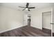 Bright bedroom with hardwood floors, a ceiling fan, white walls, and a doorway to the living space at 6600 Sw 109Th Ln, Ocala, FL 34476