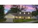 Charming home features a two-car garage, warm lighting, and a well-manicured lawn at 6600 Sw 109Th Ln, Ocala, FL 34476