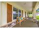 Inviting front porch with seating, decorative pillows, and stylish wood shutters at 6600 Sw 109Th Ln, Ocala, FL 34476