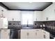 Bright kitchen with white cabinets, subway tile backsplash, stainless steel appliances, and dark counters at 6600 Sw 109Th Ln, Ocala, FL 34476