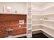 Bright laundry room with shelving, wood accent wall, and washer/dryer hookups at 6600 Sw 109Th Ln, Ocala, FL 34476
