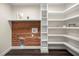Laundry room with cedar plank wall, storage shelves, and utility sink at 6600 Sw 109Th Ln, Ocala, FL 34476
