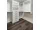 Spacious walk-in closet with wood floor, open shelving, drawers, and ample storage space at 6600 Sw 109Th Ln, Ocala, FL 34476