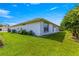 Backyard featuring a well-maintained lawn, a white exterior, and trees on a beautiful, sunny day at 6758 Sw 114Th Street Rd, Ocala, FL 34476