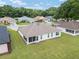 An aerial view shows a backyard with a screened lanai and a large manicured lawn at 6858 Sw 111Th Loop, Ocala, FL 34476