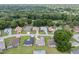 An aerial view shows a residential neighborhood with mature trees and lush green lawns at 6858 Sw 111Th Loop, Ocala, FL 34476