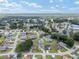 Wide aerial shot showing the community's layout, tree coverage and a distant lake at 6858 Sw 111Th Loop, Ocala, FL 34476