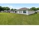 A spacious backyard featuring a well-maintained lawn and the home's exterior at 6858 Sw 111Th Loop, Ocala, FL 34476