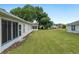 Expansive backyard showing a lush green lawn, screened in patio and exterior of the home at 6858 Sw 111Th Loop, Ocala, FL 34476