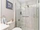 Bright bathroom features a tiled walk-in shower with glass door and seashell accents at 6858 Sw 111Th Loop, Ocala, FL 34476