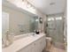 Spacious bathroom with a large mirror, vanity, and a tiled walk-in shower at 6858 Sw 111Th Loop, Ocala, FL 34476
