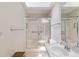 Bright bathroom with skylight, featuring a shower, vanity, and toilet at 6858 Sw 111Th Loop, Ocala, FL 34476