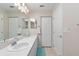 Bright bathroom with dual sinks, large mirrors, and a shower with glass doors at 6858 Sw 111Th Loop, Ocala, FL 34476