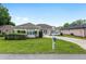 Charming single-story home with a well-manicured lawn, lush landscaping, and paved driveway at 6858 Sw 111Th Loop, Ocala, FL 34476