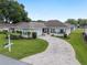 Inviting home showcasing a brick-paved driveway, well-manicured lawn, and charming front exterior with a cozy patio space at 6858 Sw 111Th Loop, Ocala, FL 34476