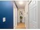 Well-lit hallway with hardwood floors and neutral walls with blue accent wall at 6858 Sw 111Th Loop, Ocala, FL 34476
