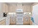 Kitchen features bright cabinets, white appliances, and tiled flooring at 6858 Sw 111Th Loop, Ocala, FL 34476