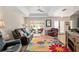 Inviting living room featuring bay window, leather sofas, tray ceilings, and hardwood floors at 6858 Sw 111Th Loop, Ocala, FL 34476