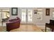 Living room view showcasing stylish seating, hardwood floors, and bright, patterned french doors at 6858 Sw 111Th Loop, Ocala, FL 34476