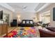 Bright living room with tray ceiling, ceiling fan, and colorful floral rug over hardwood floors at 6858 Sw 111Th Loop, Ocala, FL 34476
