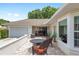 Outdoor patio features tiled flooring, cushioned wicker chairs, and adjacent views of the attached garage and landscaped yard at 6858 Sw 111Th Loop, Ocala, FL 34476