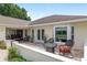 Outdoor patio features tiled flooring, cushioned wicker chairs, and adjacent views of the landscaped yard at 6858 Sw 111Th Loop, Ocala, FL 34476