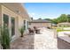 Outdoor patio features tiled flooring and wicker chairs with adjacent views of the landscaped yard at 6858 Sw 111Th Loop, Ocala, FL 34476