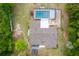 Overhead drone shot showing the house, roof and a screen enclosed pool set amongst surrounding mature trees at 8130 Sw 209Th Court Rd, Dunnellon, FL 34431
