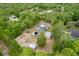 Expansive aerial view of a home with a screened pool and multiple outbuildings amidst lush greenery at 8130 Sw 209Th Court Rd, Dunnellon, FL 34431