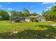 Large backyard featuring a screened-in pool, spacious lawn, and mature trees at 8130 Sw 209Th Court Rd, Dunnellon, FL 34431
