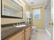 Bathroom with granite counters, wooden cabinets, and updated vanity lighting at 8130 Sw 209Th Court Rd, Dunnellon, FL 34431
