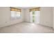 Bedroom with neutral carpet, light walls, two windows, and a sliding glass door at 8130 Sw 209Th Court Rd, Dunnellon, FL 34431