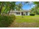 Inviting home featuring a well-manicured lawn, lush greenery, and ample natural light at 8130 Sw 209Th Court Rd, Dunnellon, FL 34431