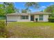 Charming one-story home boasts a neutral exterior, attached garage, and manicured front lawn at 8130 Sw 209Th Court Rd, Dunnellon, FL 34431