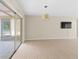 Spacious living room featuring tile flooring, modern light fixture, and sliding glass doors at 8130 Sw 209Th Court Rd, Dunnellon, FL 34431