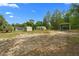 A ground level shot showcasing a couple of outbuildings, with the house and pool in the background at 8130 Sw 209Th Court Rd, Dunnellon, FL 34431