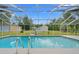 A screened in pool with a ladder for access on a bright sunny day at 8130 Sw 209Th Court Rd, Dunnellon, FL 34431